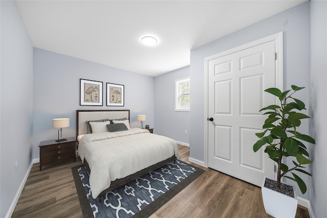 bedroom with baseboards and wood finished floors