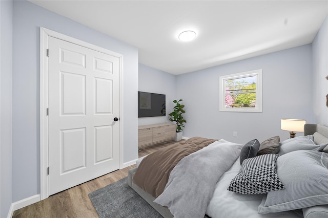 bedroom with baseboards and wood finished floors