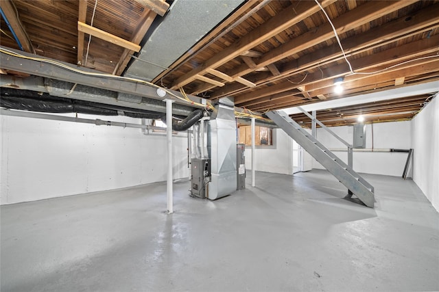 unfinished below grade area featuring heating unit and electric panel