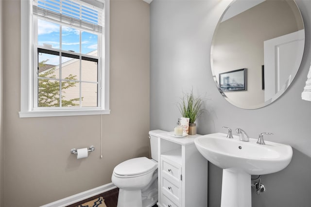 bathroom with baseboards, toilet, and wood finished floors
