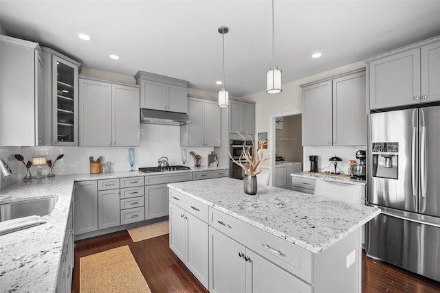kitchen with appliances with stainless steel finishes, washing machine and dryer, and gray cabinets