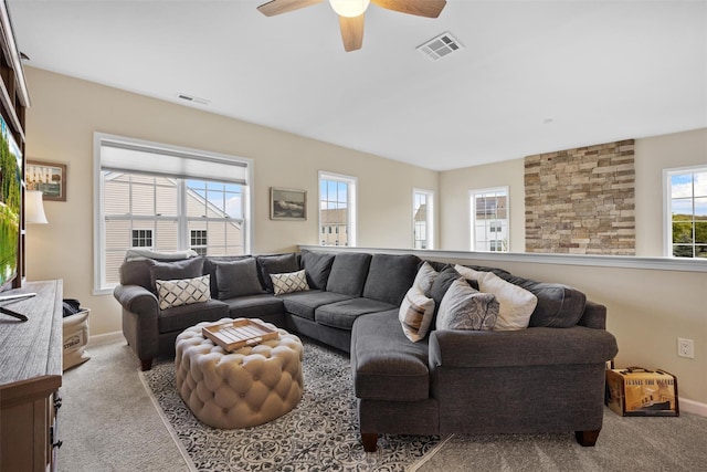 living room with carpet floors, a ceiling fan, and visible vents