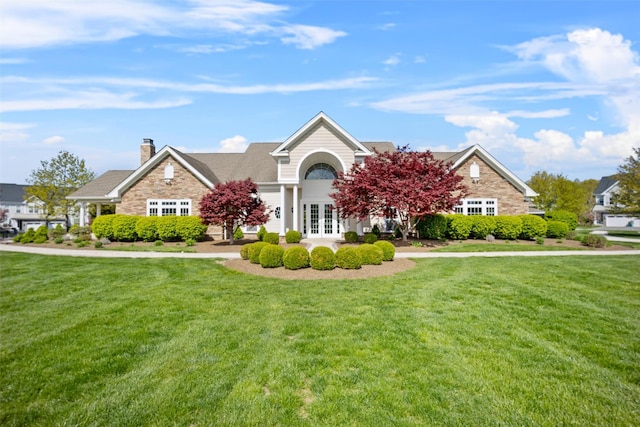 view of front of home featuring a front lawn, french doors, and a chimney