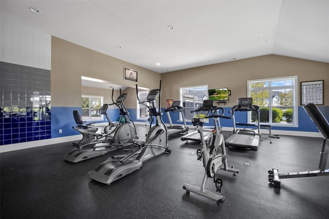workout area featuring baseboards and vaulted ceiling