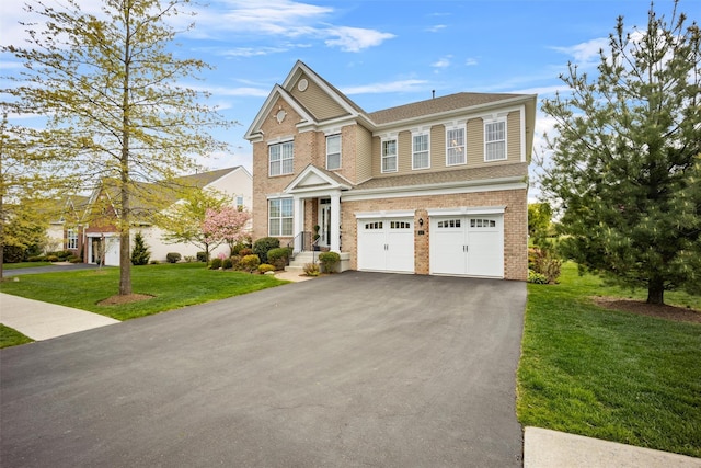 view of front of home featuring brick siding, driveway, a front yard, and a garage