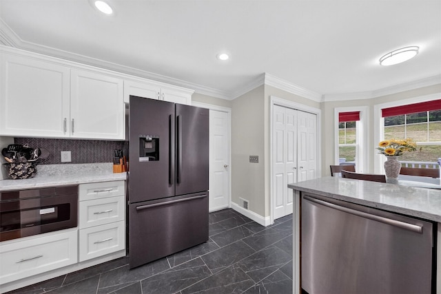 50 Roosevelt Dr, Poughquag, NY 12570 - kitchen with freestanding refrigerator, stainless steel dishwasher, white cabinetry, crown molding, and light stone counters