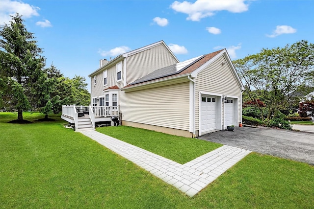50 Roosevelt Dr, Poughquag, NY 12570 - view of side of property with driveway, solar panels, a garage, a chimney, and a yard