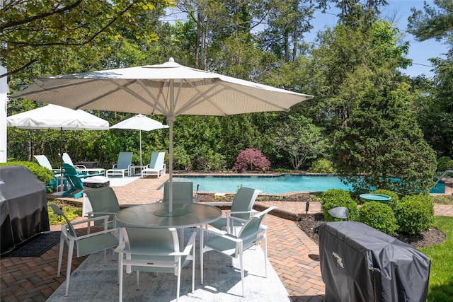 94 Schoolhouse Ln, Roslyn Heights, NY 11577 - view of patio with outdoor dining space, an outdoor pool, and view of wooded area