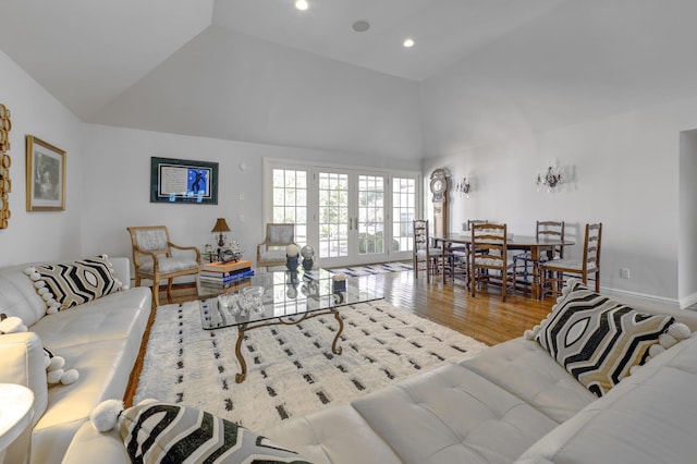 94 Schoolhouse Ln, Roslyn Heights, NY 11577 - living area featuring wood finished floors, high vaulted ceiling, french doors, and recessed lighting
