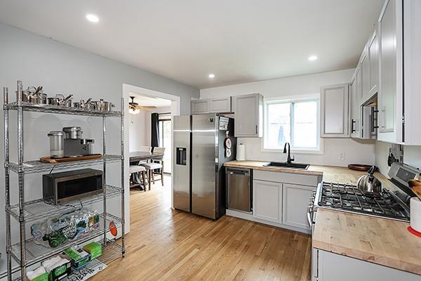 kitchen featuring appliances with stainless steel finishes, a sink, light wood-style floors, recessed lighting, and a ceiling fan