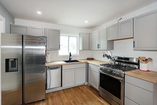 kitchen with light wood-style floors, recessed lighting, light countertops, a sink, and appliances with stainless steel finishes