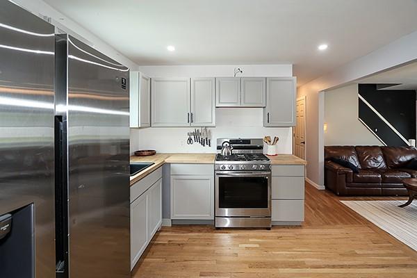 kitchen with open floor plan, recessed lighting, light countertops, light wood-style flooring, and appliances with stainless steel finishes