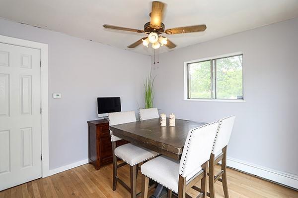 dining space featuring baseboards, a ceiling fan, light wood-style flooring, and baseboard heating