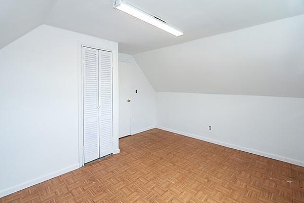 bonus room with baseboards and vaulted ceiling