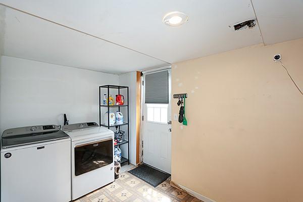 laundry area featuring light floors, baseboards, laundry area, and washer and dryer