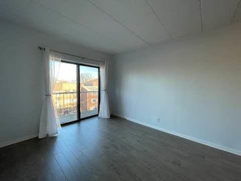 unfurnished room with dark wood-style flooring and baseboards
