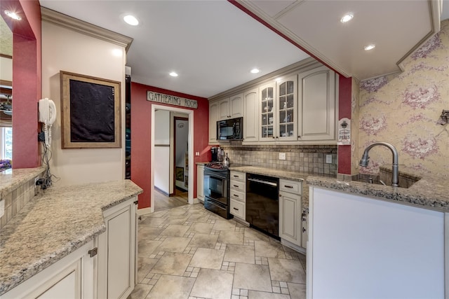 kitchen featuring black appliances, a sink, light stone finish floors, glass insert cabinets, and recessed lighting