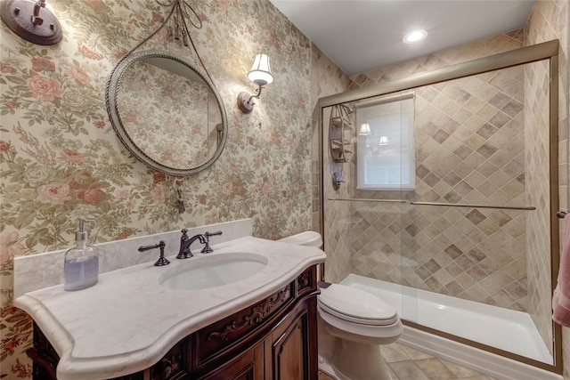 full bath with toilet, wallpapered walls, a stall shower, tile patterned floors, and vanity
