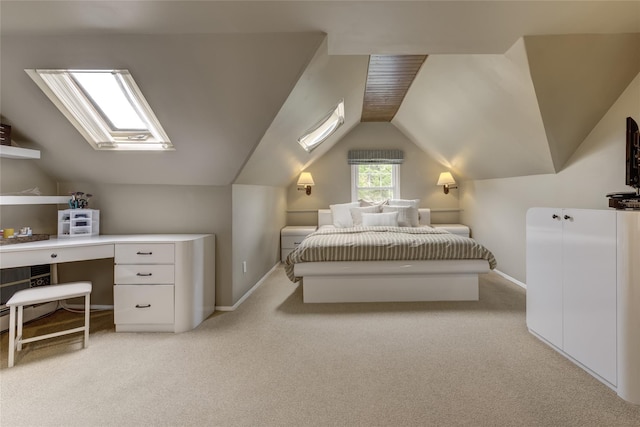 bedroom with vaulted ceiling, light carpet, a skylight, and baseboards