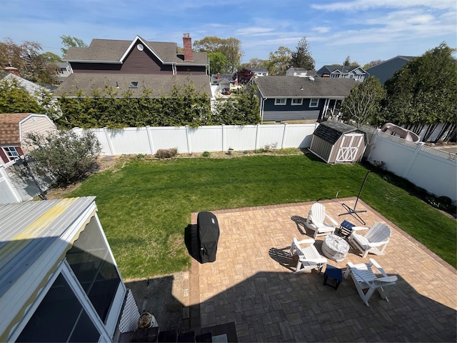 view of yard with a storage shed, an outdoor structure, a fenced backyard, and a patio area