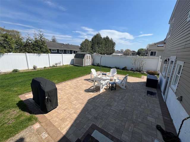 view of patio with a storage shed, an outbuilding, and a fenced backyard