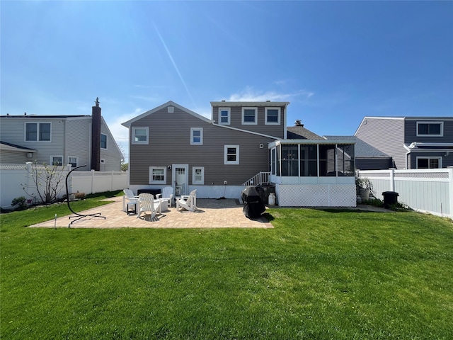 rear view of property featuring a lawn, a fenced backyard, a patio area, and a sunroom
