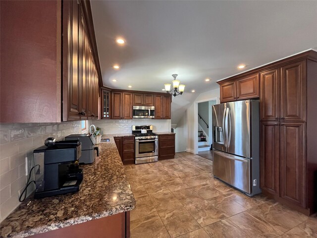 kitchen with dark stone counters, appliances with stainless steel finishes, tasteful backsplash, and a chandelier