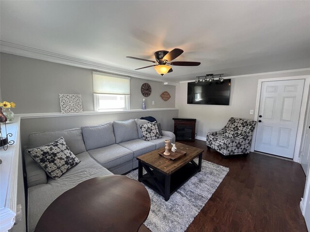 living room featuring crown molding, a ceiling fan, baseboards, and dark wood-type flooring