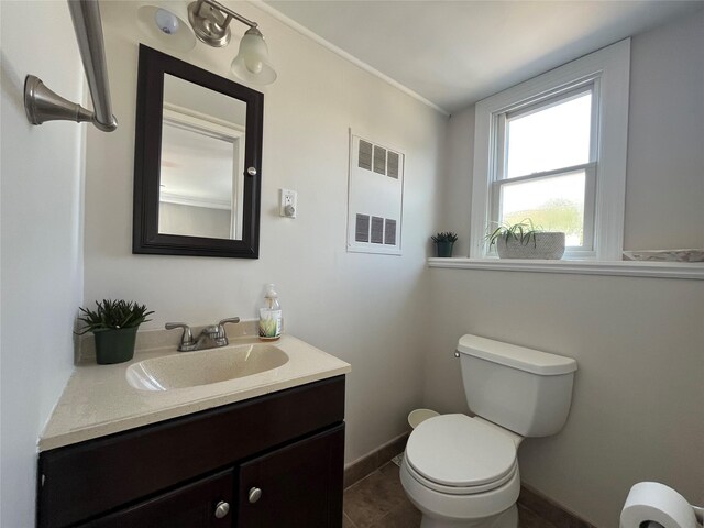 bathroom featuring vanity, toilet, tile patterned floors, baseboards, and visible vents