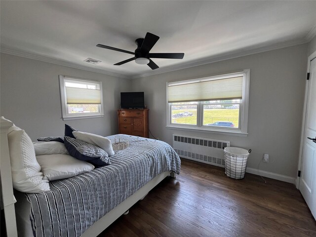 bedroom featuring radiator heating unit, multiple windows, ornamental molding, and visible vents