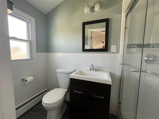 bathroom with a shower stall, a baseboard heating unit, toilet, and tile walls