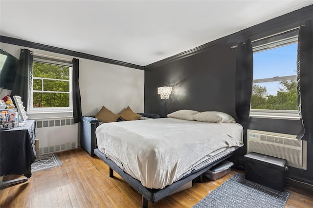 153-25 88th St Unit 3D, Howard Beach, NY 11414 - bedroom featuring radiator, ornamental molding, wood finished floors, and an AC wall unit