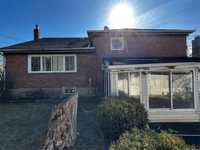 827 Eastfield Rd, Westbury, NY 11590 - back of property featuring a chimney, a sunroom, and brick siding
