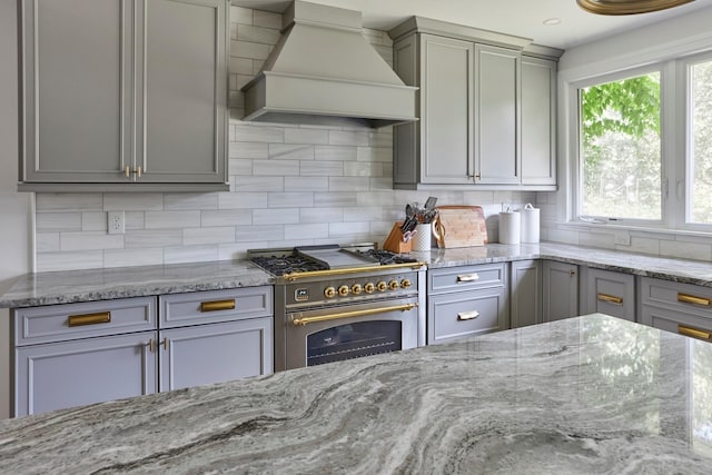 78 Schultz Hill Rd, Rhinebeck, NY 12580 - kitchen with premium range hood, stainless steel stove, gray cabinets, decorative backsplash, and light stone counters