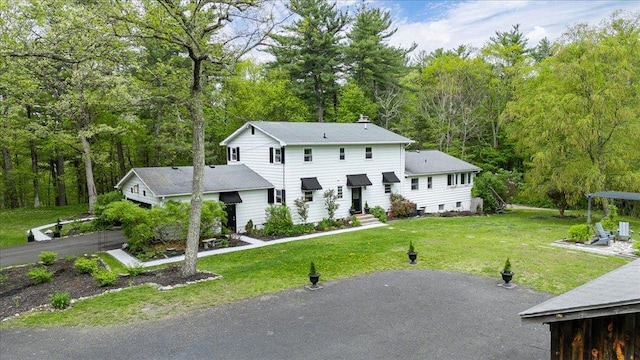 78 Schultz Hill Rd, Rhinebeck, NY 12580 - view of front of house featuring a front lawn, a view of trees, driveway, and a chimney