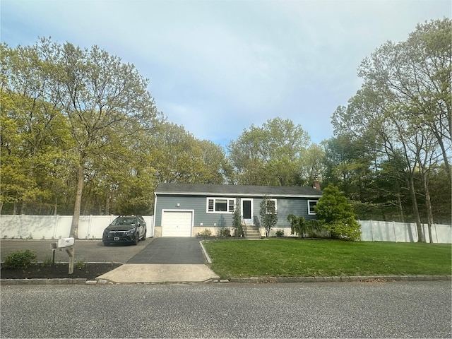 ranch-style house featuring a garage, aphalt driveway, fence, and a front yard