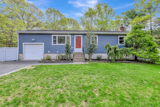 ranch-style home featuring a chimney, driveway, fence, an attached garage, and a front yard