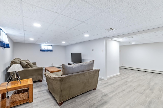living room with a baseboard heating unit, visible vents, recessed lighting, light wood finished floors, and a paneled ceiling