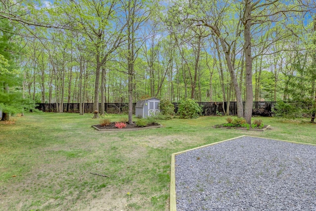 view of yard with a fenced backyard, an outbuilding, and a storage shed