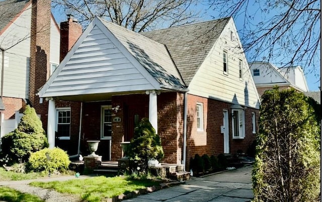 bungalow-style home with a porch and brick siding