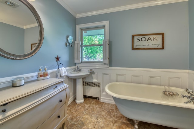 bathroom with crown molding, tile patterned flooring, radiator heating unit, a freestanding bath, and a wainscoted wall