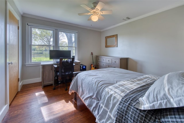 bedroom featuring visible vents, crown molding, wood finished floors, baseboards, and ceiling fan