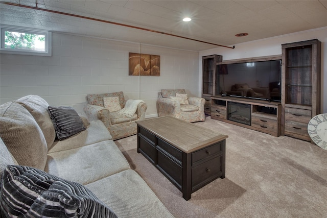 living room with concrete block wall, light carpet, and recessed lighting