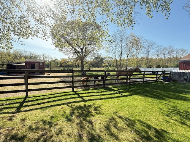 view of yard featuring an exterior structure, fence, and an outbuilding
