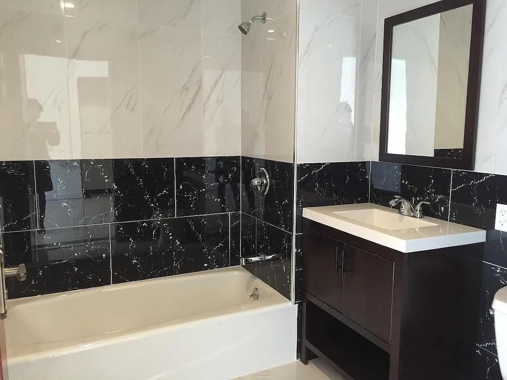 full bathroom featuring washtub / shower combination and vanity