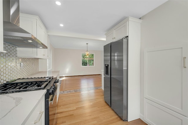 77 Greenwood Ln, White Plains, NY 10607 - kitchen featuring appliances with stainless steel finishes, wall chimney range hood, light wood-style floors, backsplash, and white cabinetry