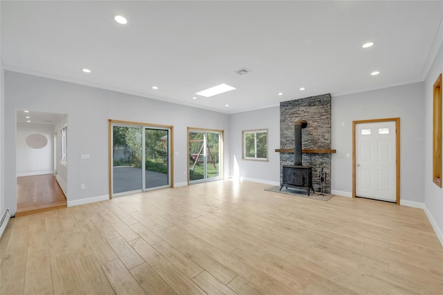 77 Greenwood Ln, White Plains, NY 10607 - unfurnished living room with plenty of natural light, a wood stove, light wood-type flooring, baseboards, and recessed lighting