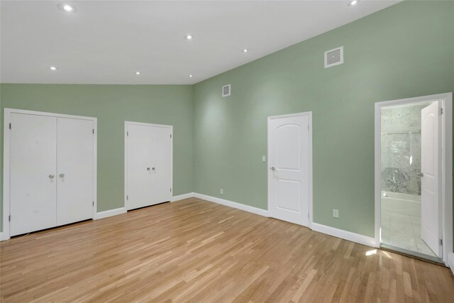 77 Greenwood Ln, White Plains, NY 10607 - unfurnished bedroom featuring high vaulted ceiling, light wood-style flooring, baseboards, ensuite bath, and multiple closets