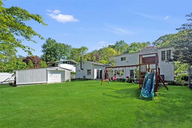 77 Greenwood Ln, White Plains, NY 10607 - back of house featuring a playground, a detached garage, a yard, and an outdoor structure
