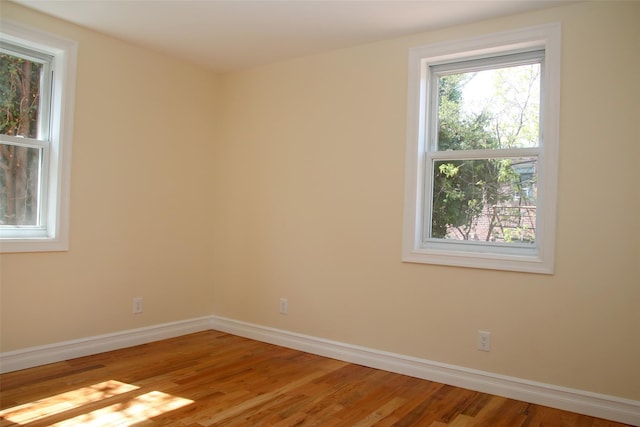 unfurnished room with baseboards and light wood finished floors